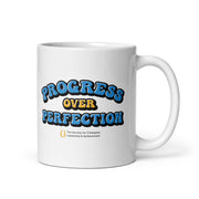 White mug with 'Progress Over Perfection' text on a white background